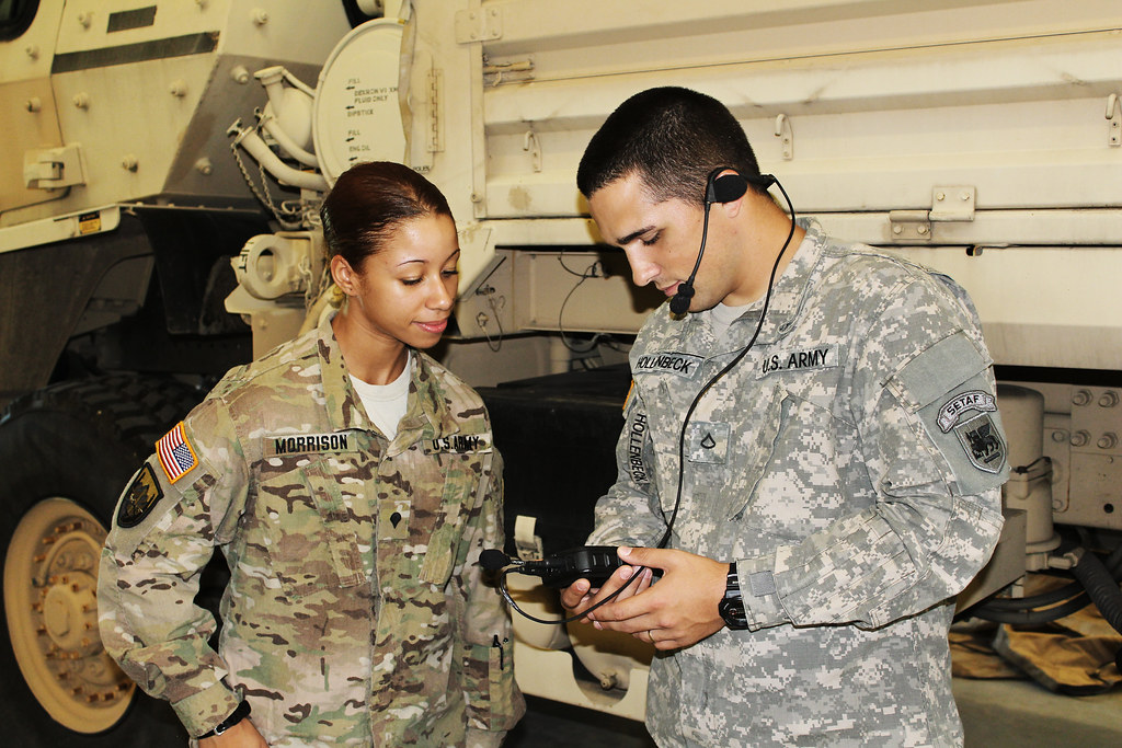 A soldier uses a language translation device during a field operation, illustrating real-time translation technology in action.