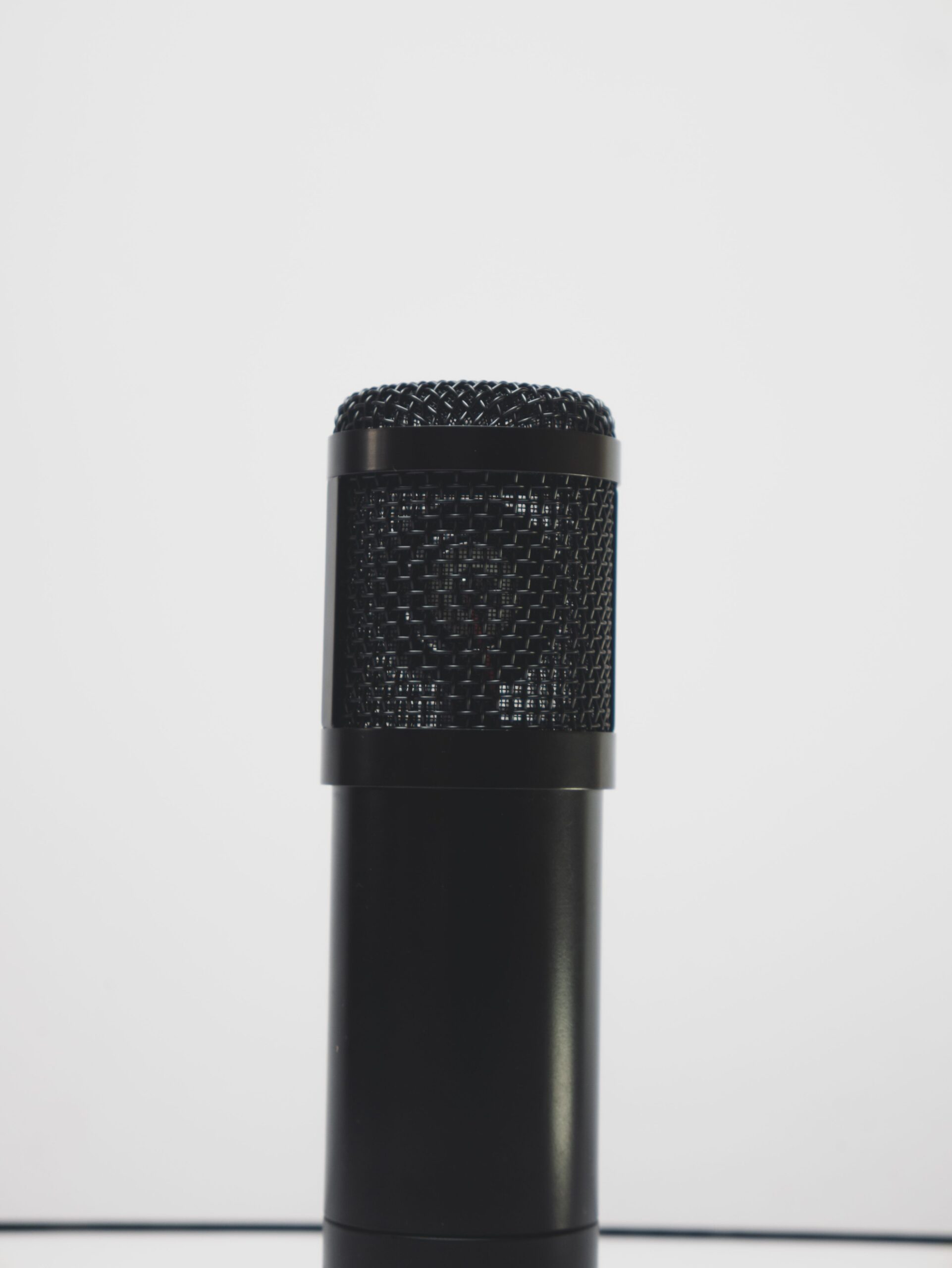 Photo by Blaq1sensei, Pexels License, via Pexels A close-up of a black microphone against a white background