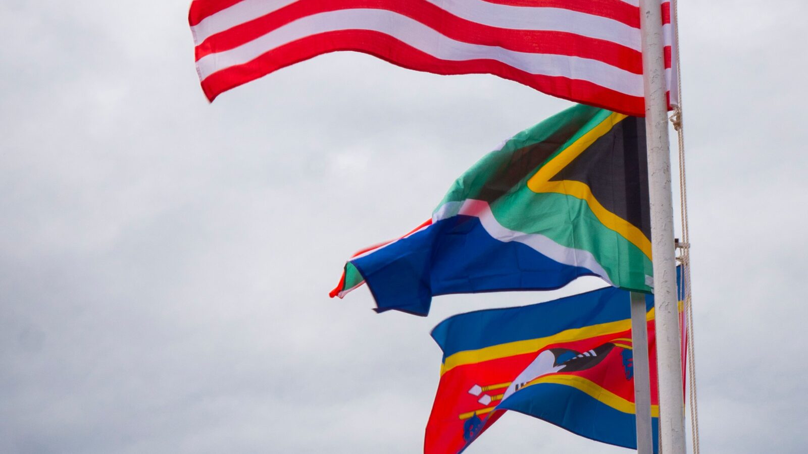 A row of national flags flying in the wind, representing a multilingual community communicating across languages