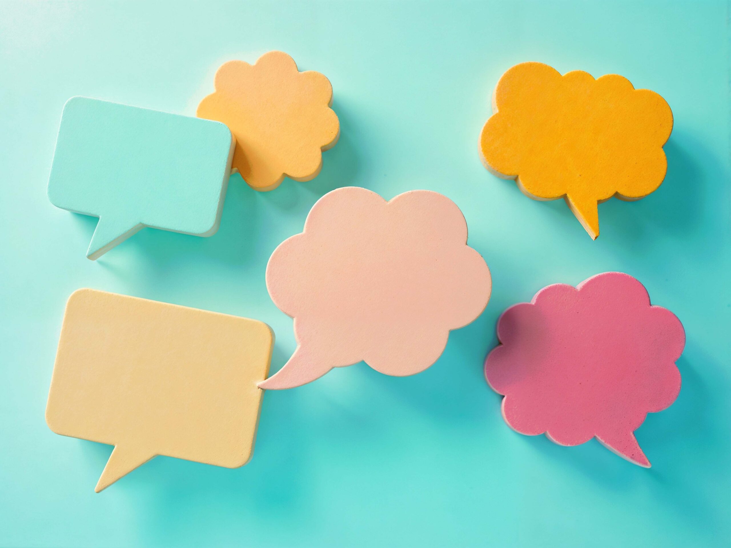 HamzaSamadh, Pexels License, via Pexels Colorful blank speech bubbles arranged on a teal background representing multilingual communication