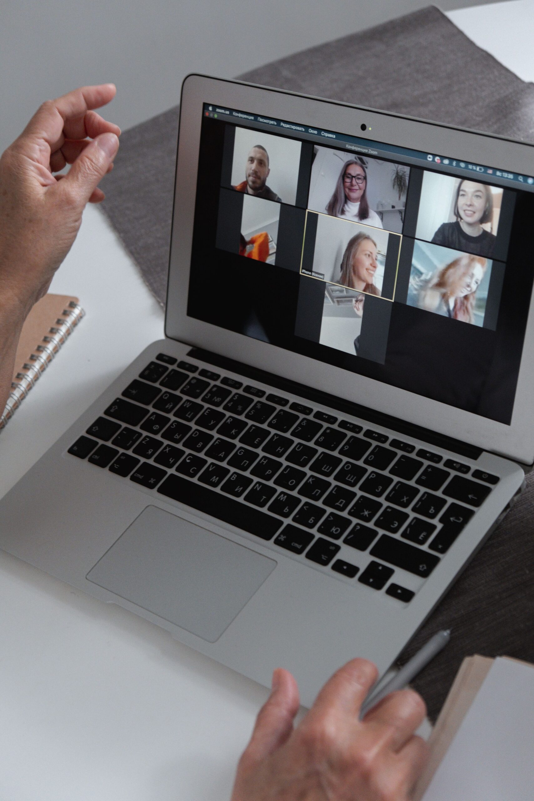 A laptop showing a video call with several participants, like the international teams a Discord translator bot connects.