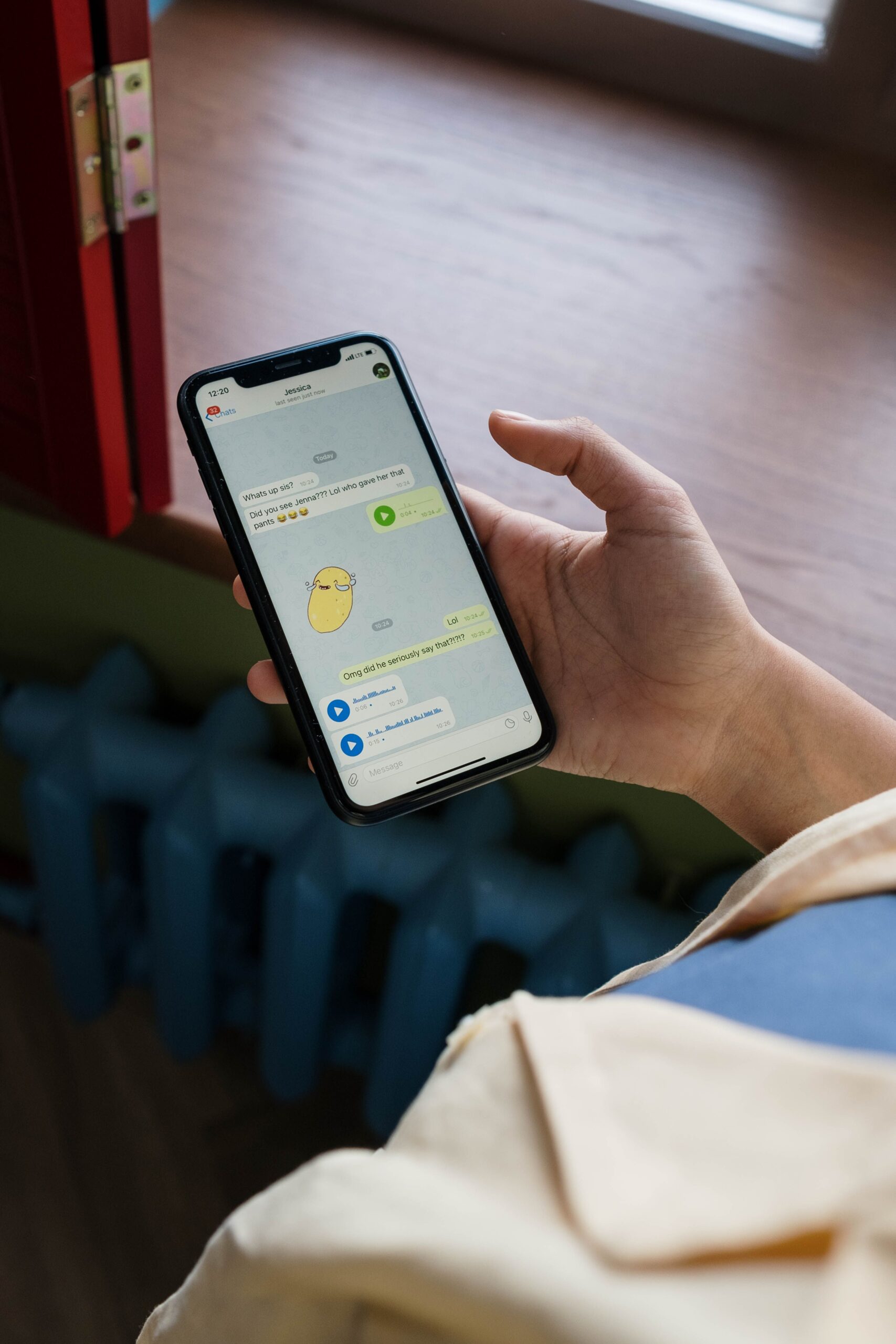 A hand holding a smartphone open to a chat conversation