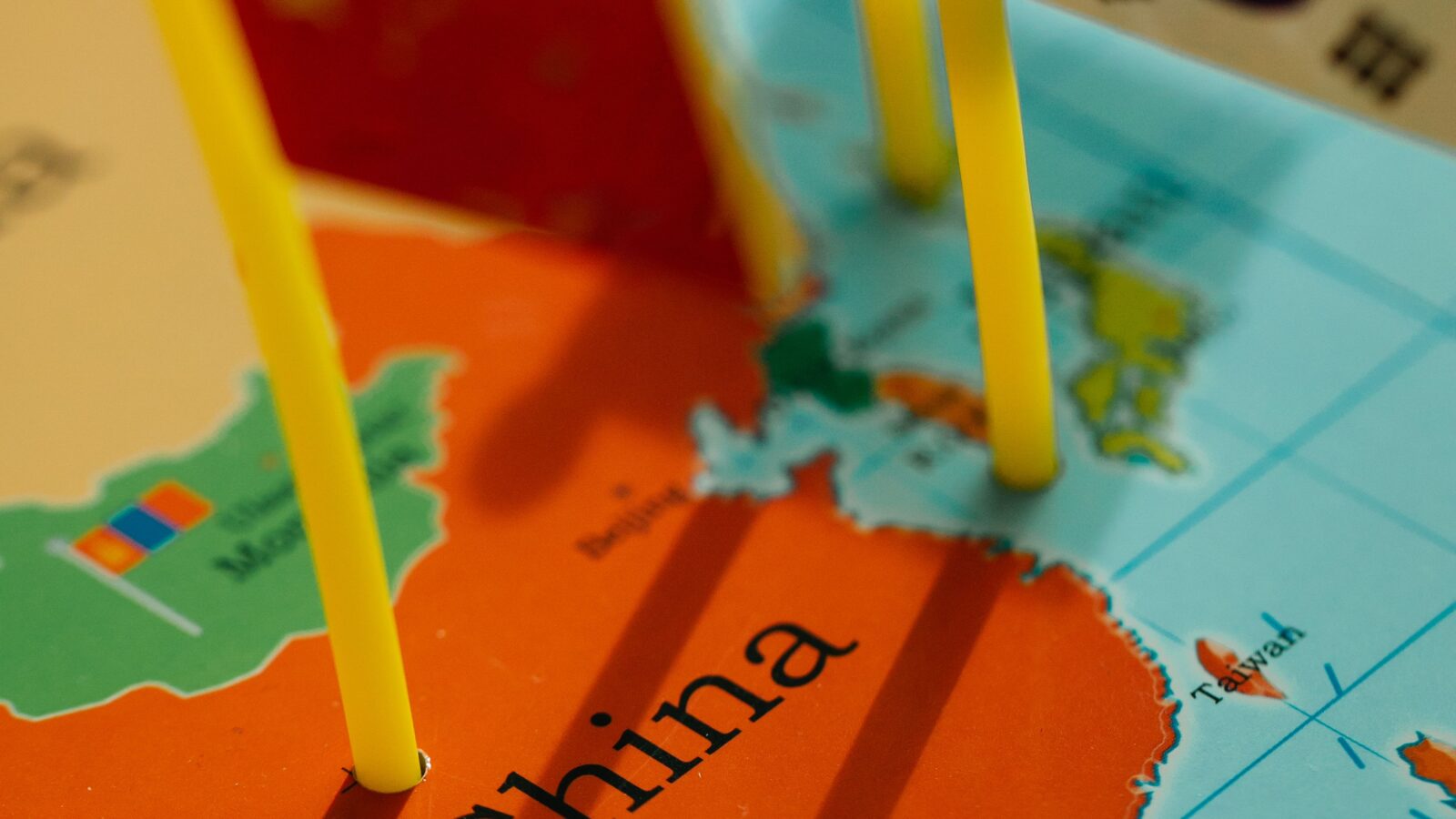 Close-up of a world map with small country flag pins stuck into it, representing a multilingual community