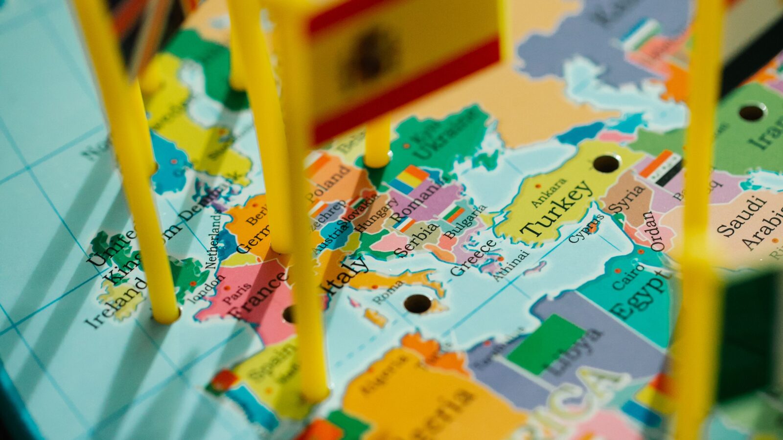 A globe with flag pins marking countries, representing the international multilingual communities that translation bots serve on Discord