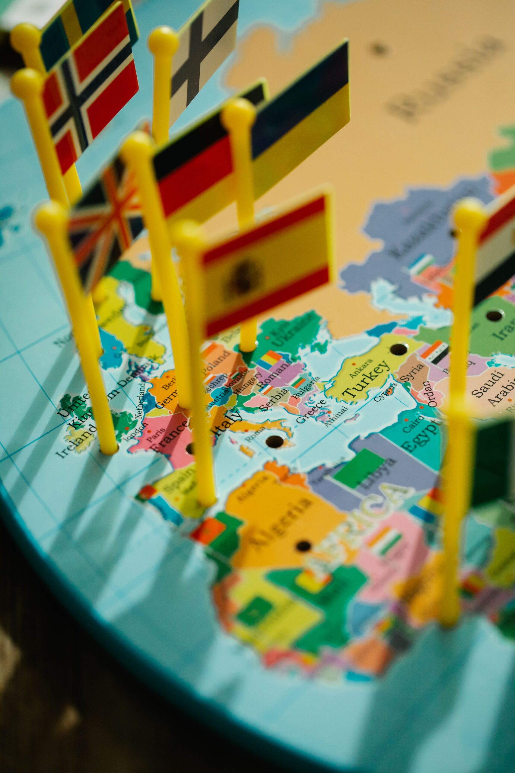 lara-jameson, Pexels License, via https://www.pexels.com/photo/flags-on-a-map-8828597/ A map of Europe and the Mediterranean with small national flag pins, showing several languages meeting in one community
