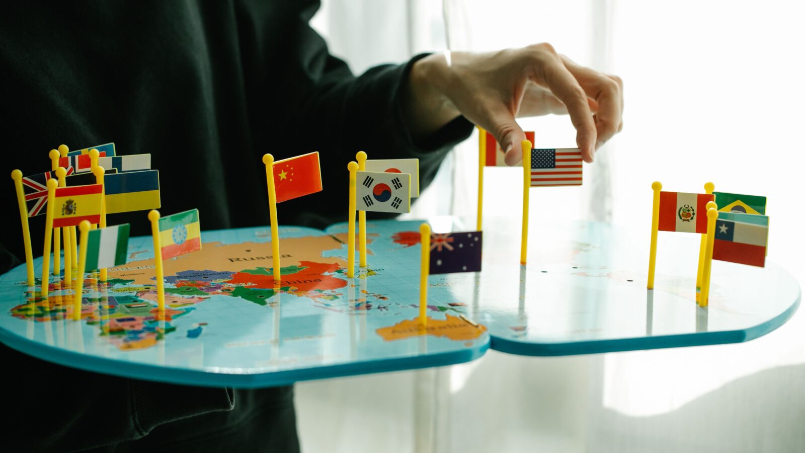 Small national flags pinned on a world map, representing the multilingual communities a Discord translator bot is built to connect.
