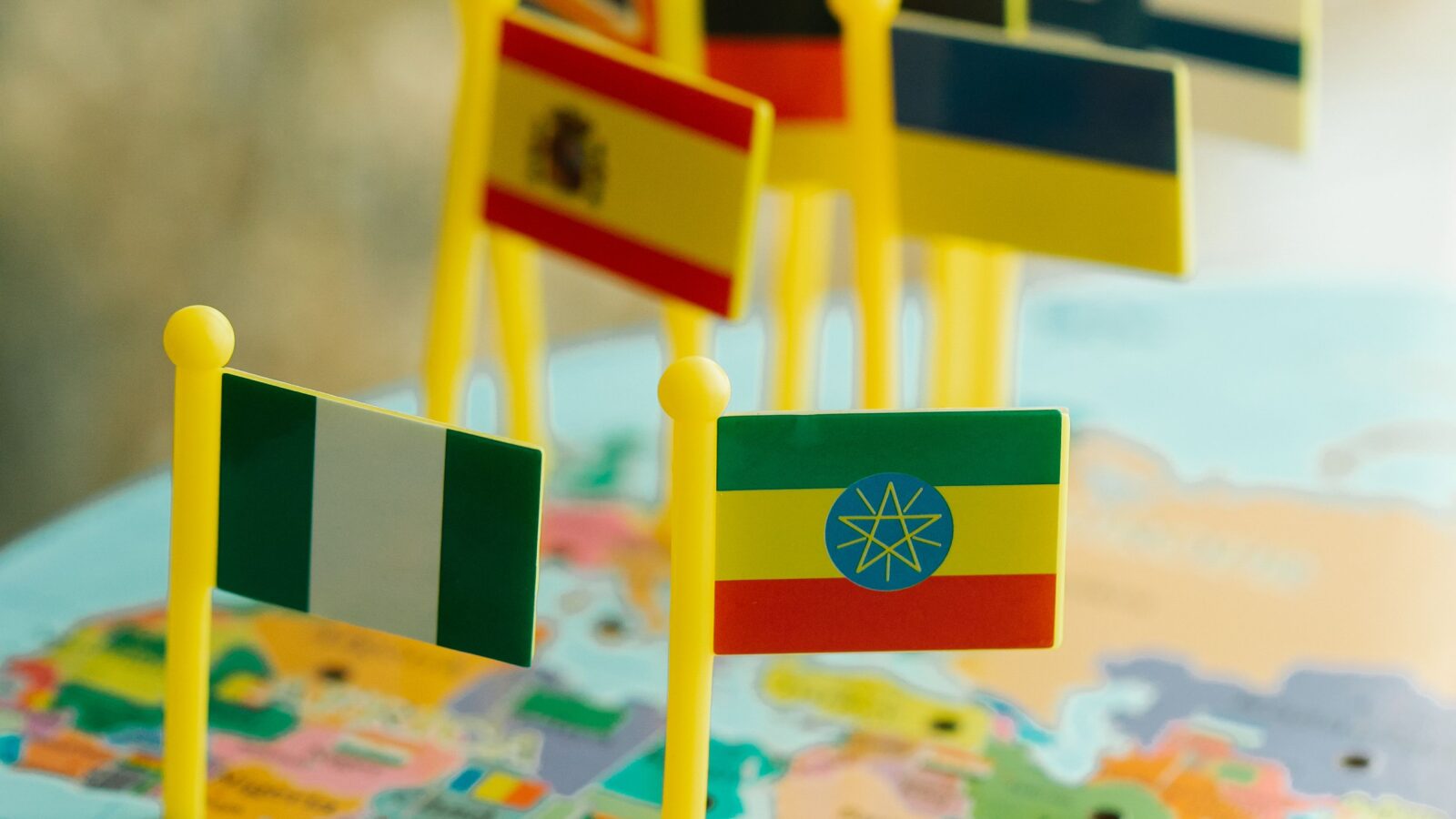 Colorful toy country flags pinned on a world map, representing a multilingual Discord server